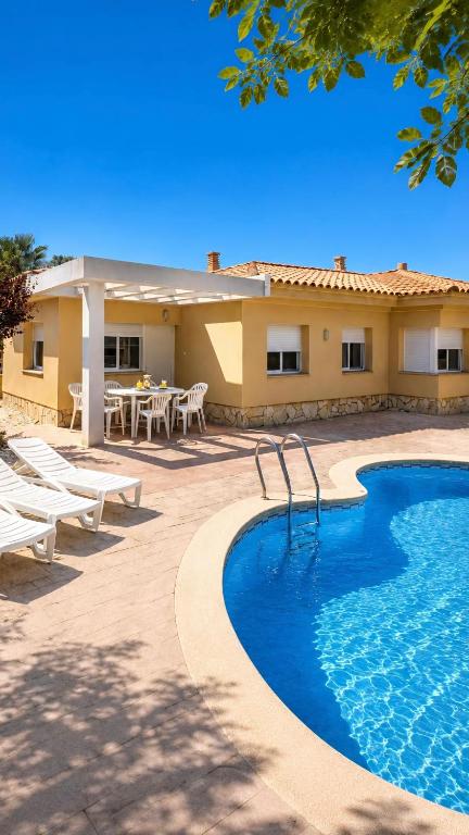 a resort with a swimming pool and a table and chairs at Casa Mañet - "Pet Friendly - Piscina Privada - Playa - BBQ - Parking - Delta de l'Ebre - Riumar" in Riumar