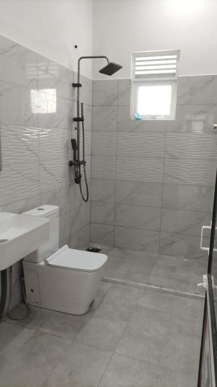 a bathroom with a shower and a toilet and a sink at Suriya villa in Poddala