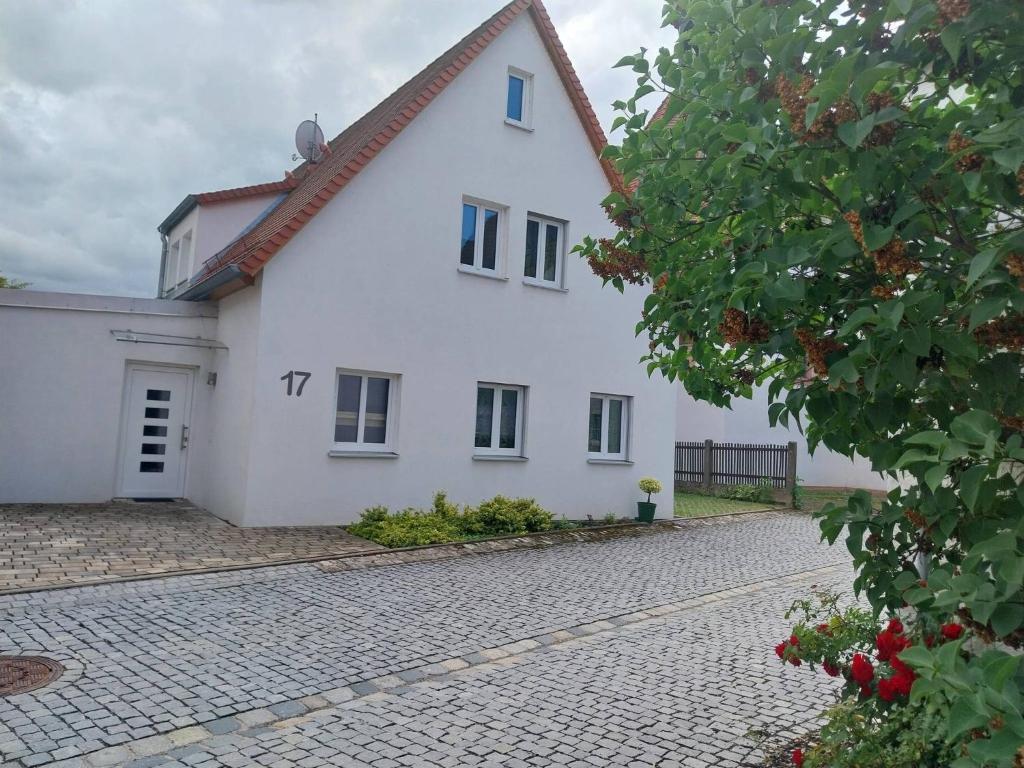 a large white house with a cobblestone driveway at Herrmanns-Ferienhaus Steigerwald in Schlüsselfeld