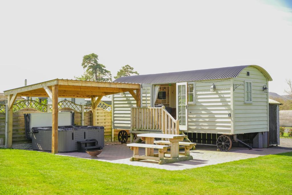 a green tiny house with a picnic table and a grill at Sunflower in Saint Harmon