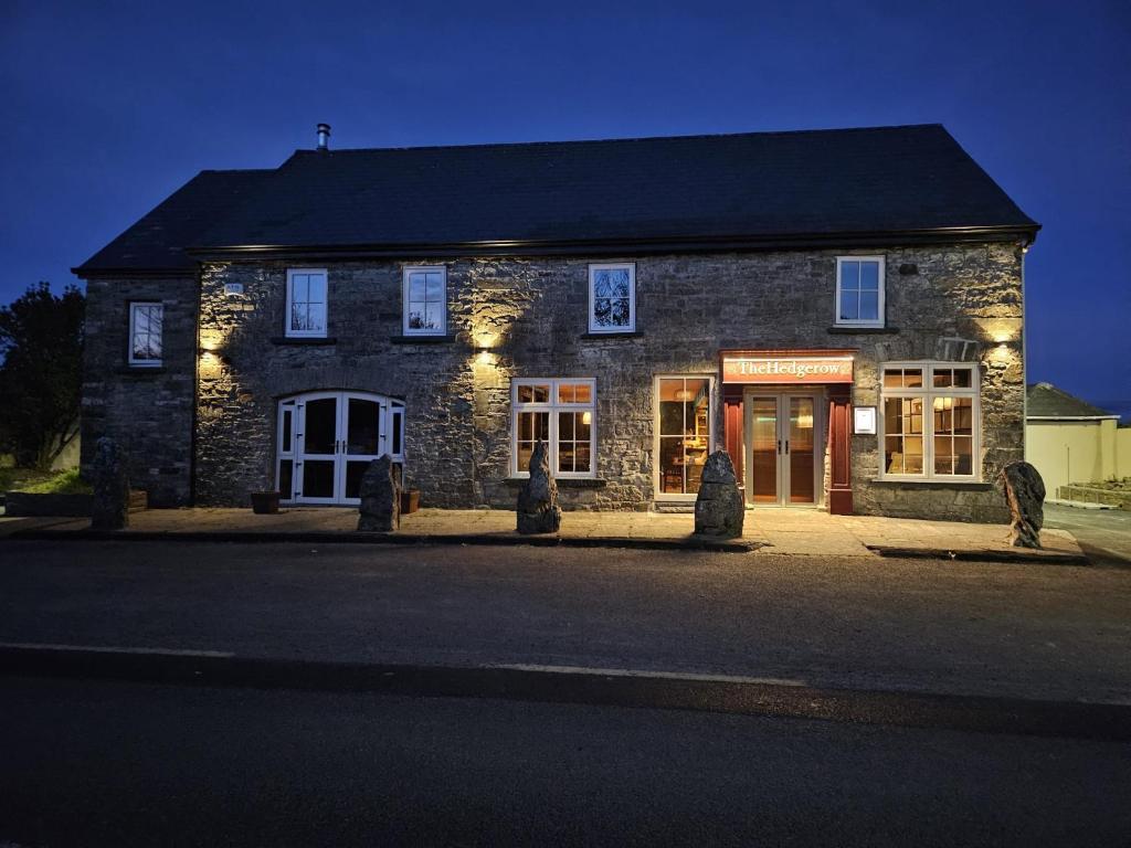 a stone building with lights on the front of it at The Hedgerow Kilshanny in Kilshanny