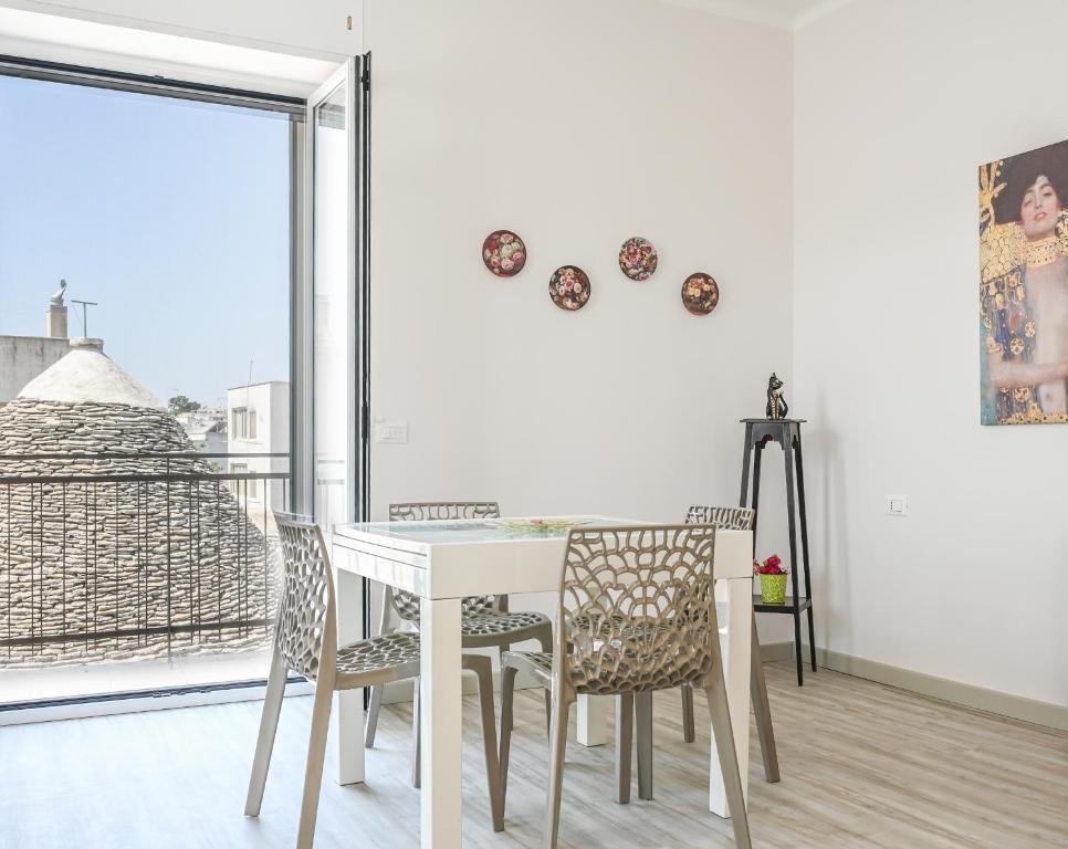 a dining room with a white table and chairs at Il rifugio di eva in Alberobello