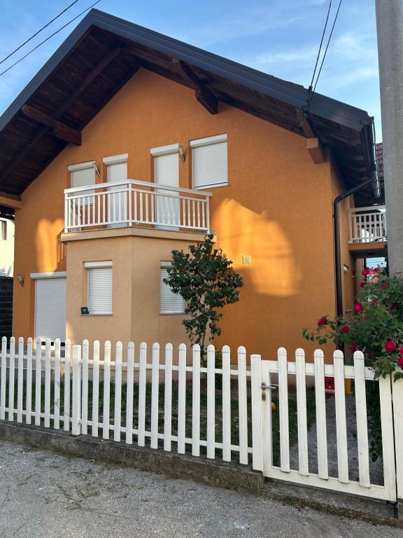 a yellow house with a white picket fence at Sarajevo Villa Oasis in Doglodi