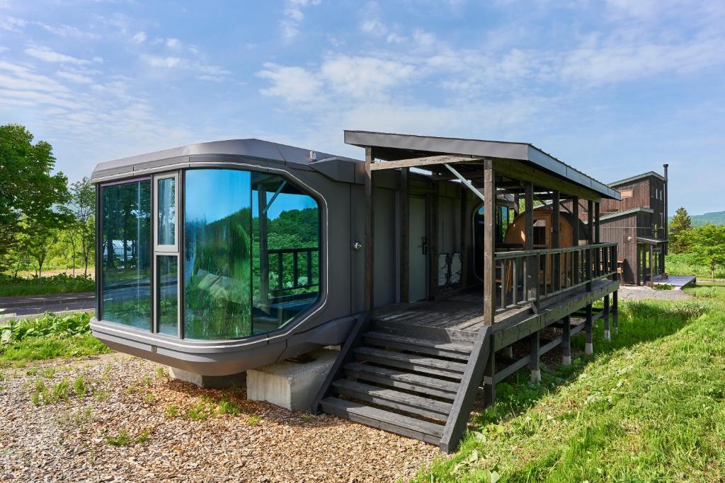 a tiny house sitting on top of a field at Straddie Island in Niseko