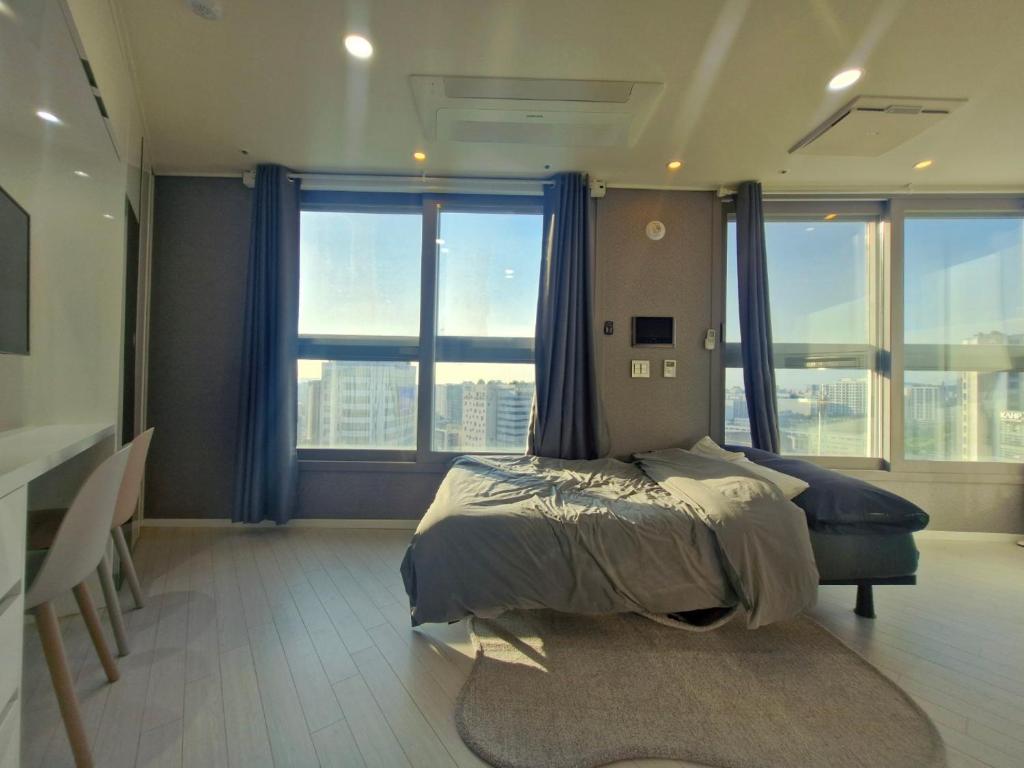a bedroom with a bed and a large window at Sj라벨라 강서 in Samgong