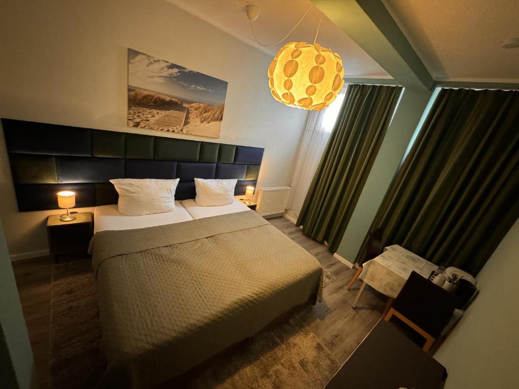 a bedroom with a large bed and a chandelier at Limo Stay in Neuhausen auf den Fildern