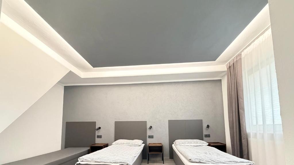two beds in a room with a ceiling at Domek 80m2 na wyłączność in Tczew