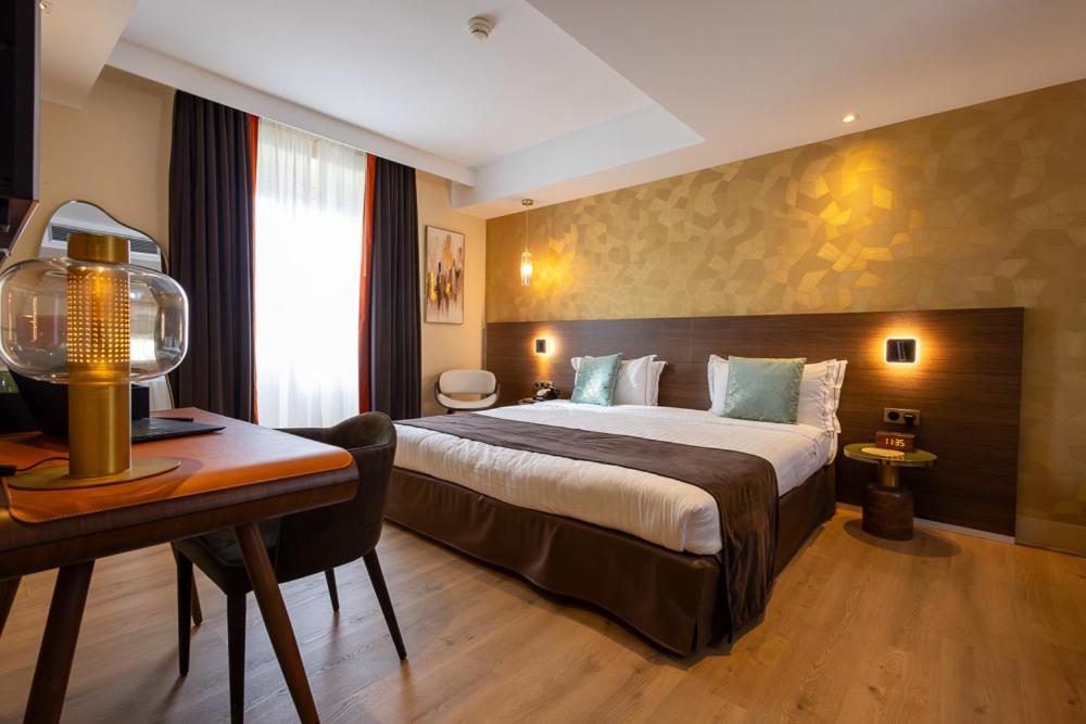 a hotel room with a bed and a desk at Hotel Parc Eiffel in Paris
