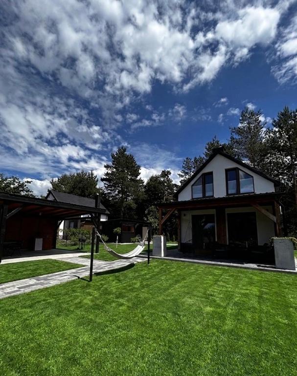 a house with a hammock in front of a yard at 10 osobowy Bania House Okuninka rowerek wodny jacuzzi sauna 1200 m do centrum Okuninki 6 km do Włodawy in Włodawa