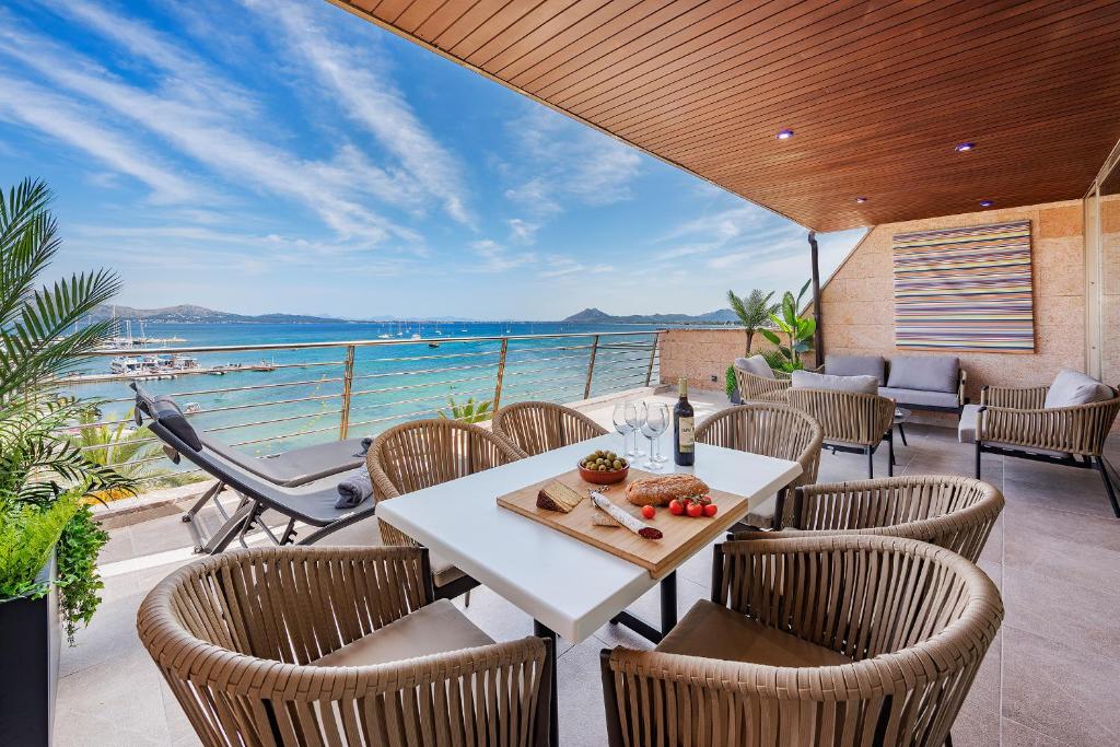a table and chairs on a patio with a view of the ocean at Apartment Vistamar IV in Port de Pollensa