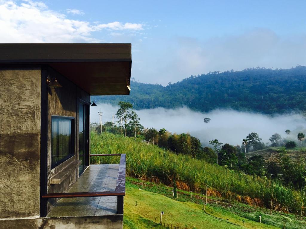 a house with a balcony with a view of a mountain at Bann Ton Kho in Khao Kho