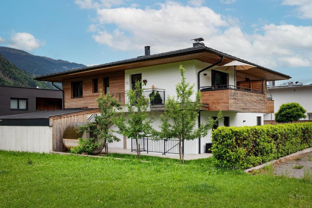 a house with a balcony on top of a yard at Appartement Carmen in Uderns