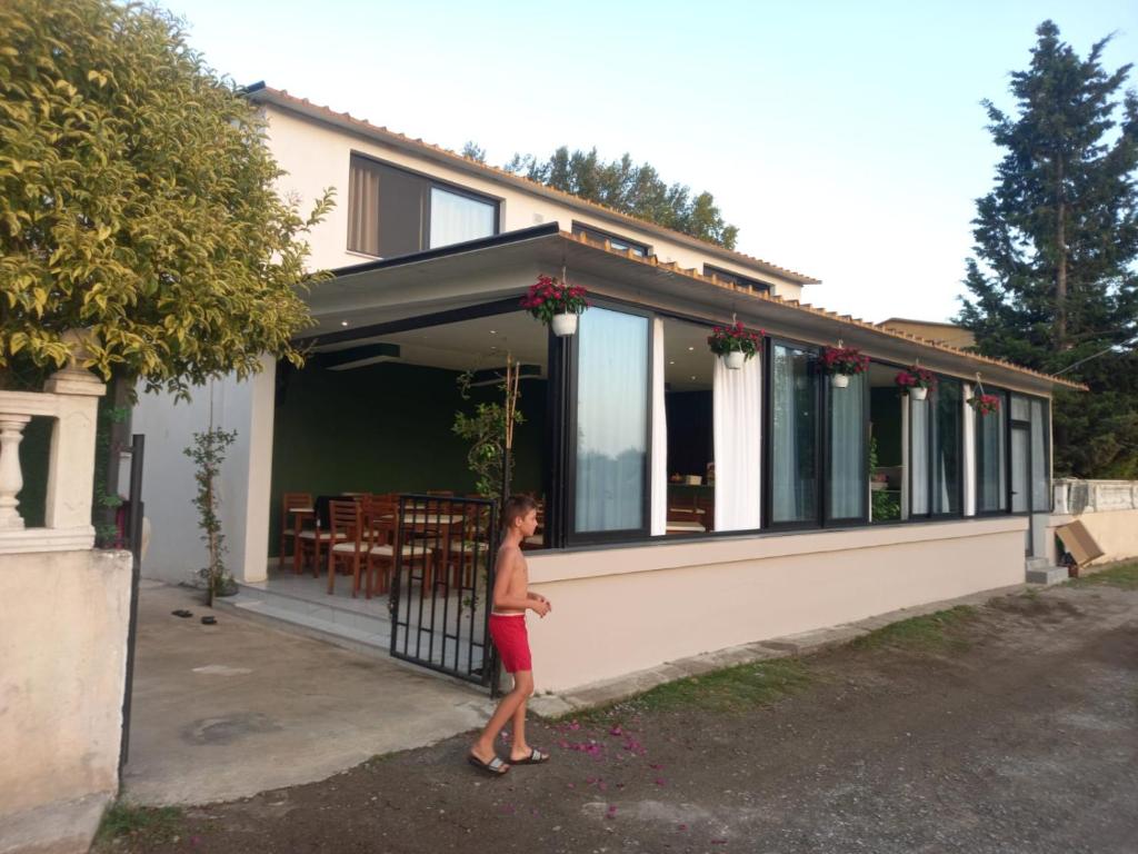 a young man standing outside of a house at TE Shkodrant 1 in Baks-Rrjoll