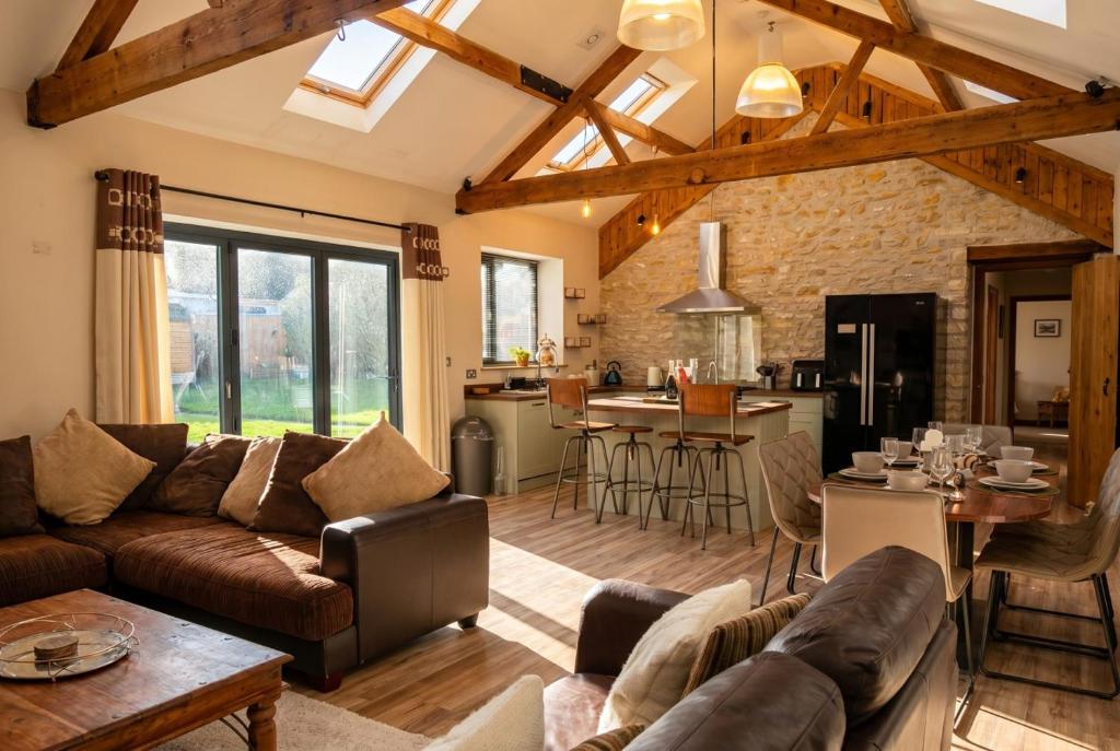 a living room with a couch and a kitchen at Lynwood Barn - Barn Conversion in Midsomer Norton, Parking & Dog Friendly in Radstock