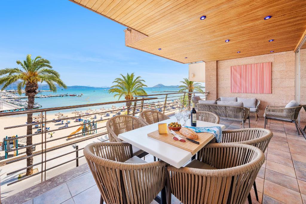 a patio with a table and chairs and a view of the beach at Apartment Vistamar III in Port de Pollensa