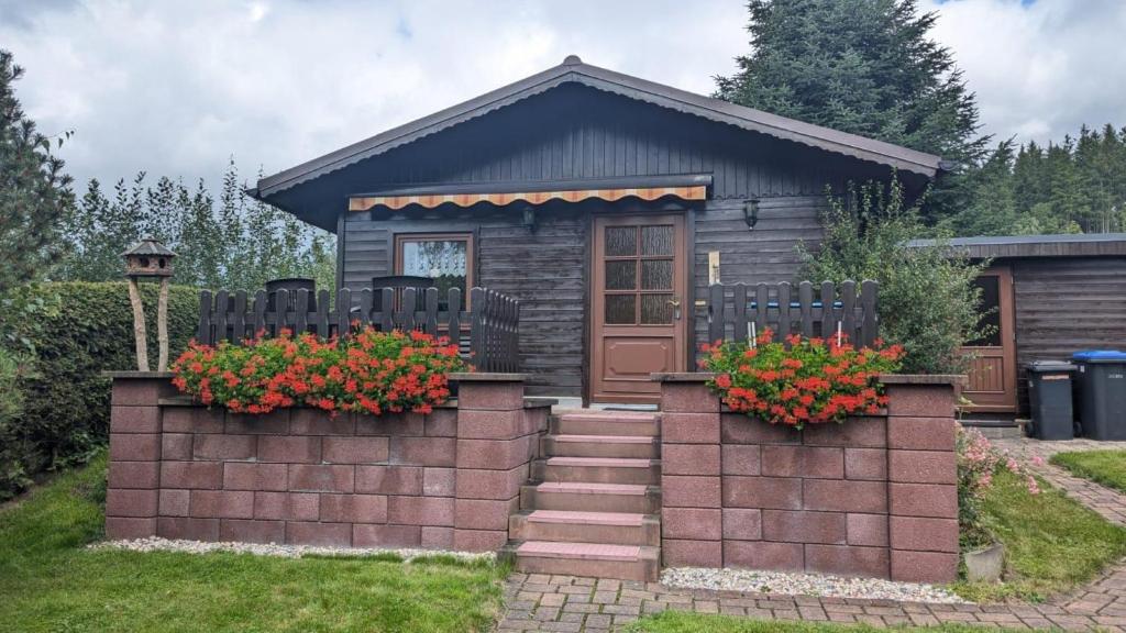 a tiny house with flowers in front of it at Ferienhaus am Wald in Augsburg