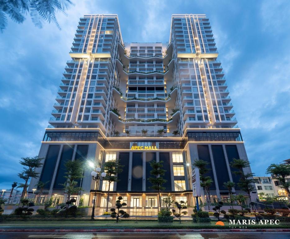 two tall buildings in front of a building at Maris Apec Tuy Hoà in Tuy Hoa