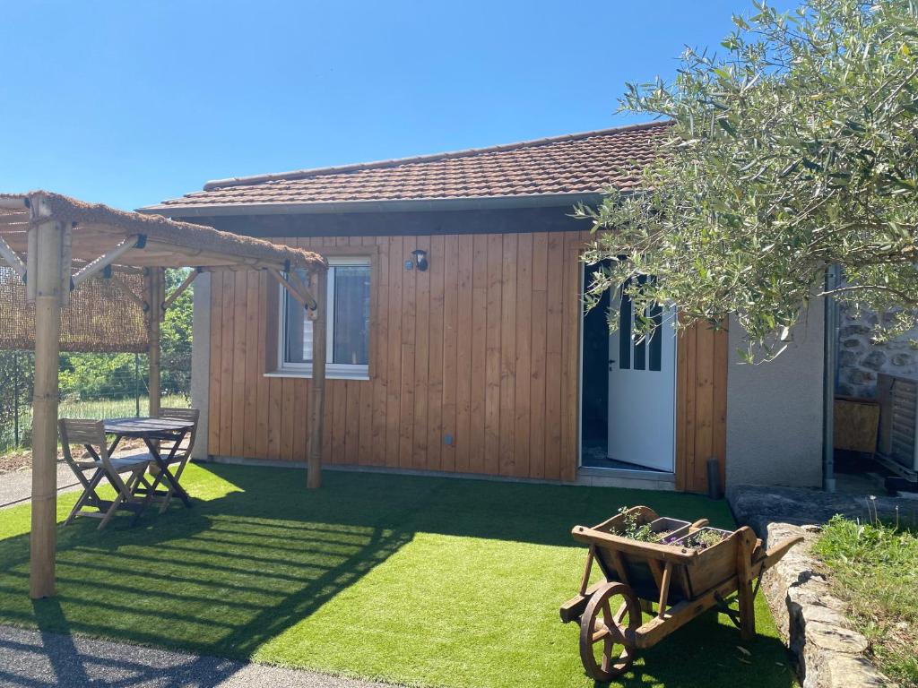 a backyard with a picnic table and a shed at Chambre Ephédra in Sampzon