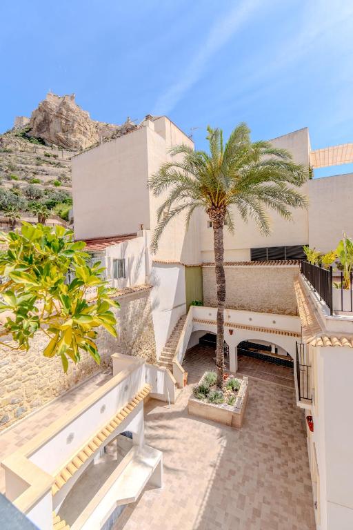 a balcony with palm trees and a building at Hotel Boutique Porta Ferrisa in Alicante