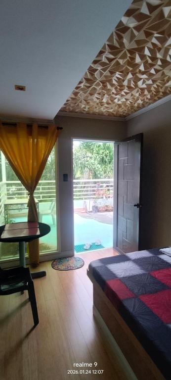 a bedroom with a bed and a table and a window at Gerry's Place in Iloilo City