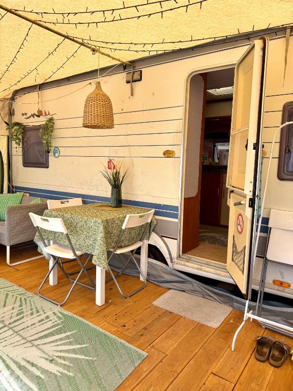 a caravan with a table and chairs in front of it at Highway to Hel in Jastarnia