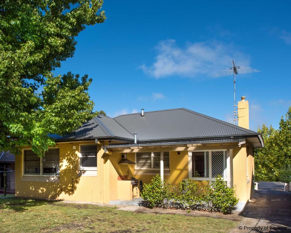 a yellow house with a black roof at Echo Point Village in Katoomba