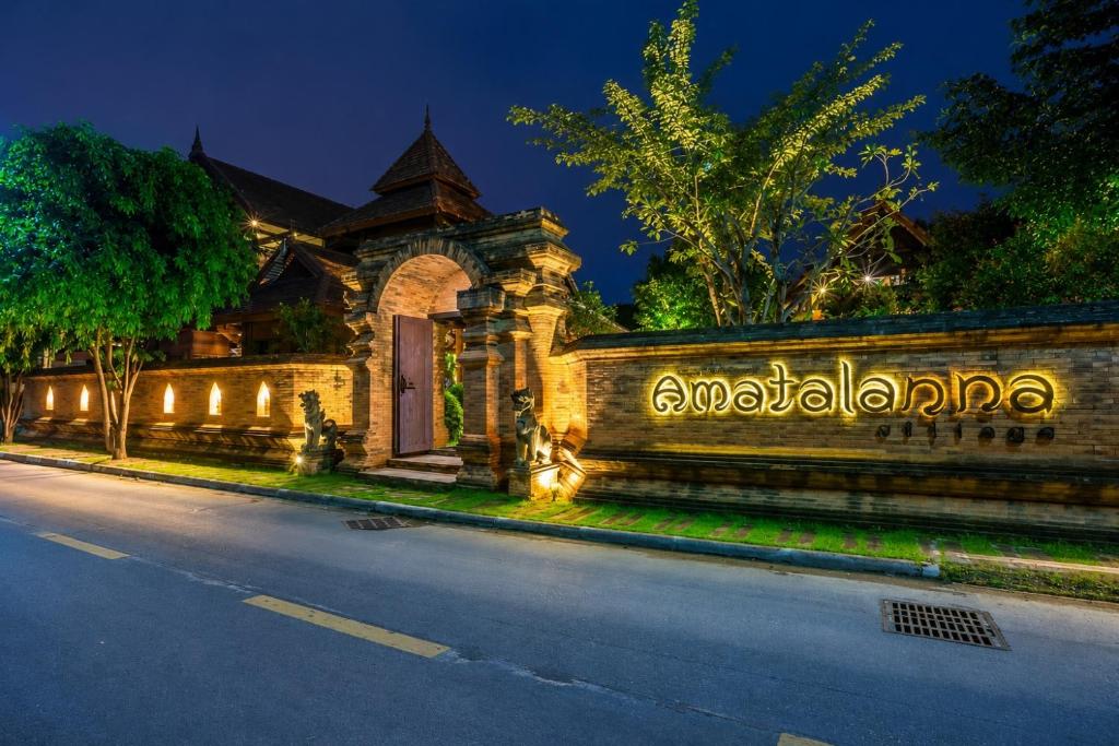 a building with a gate and a street at night at Amatalannavillage Chiangmai in Chiang Mai