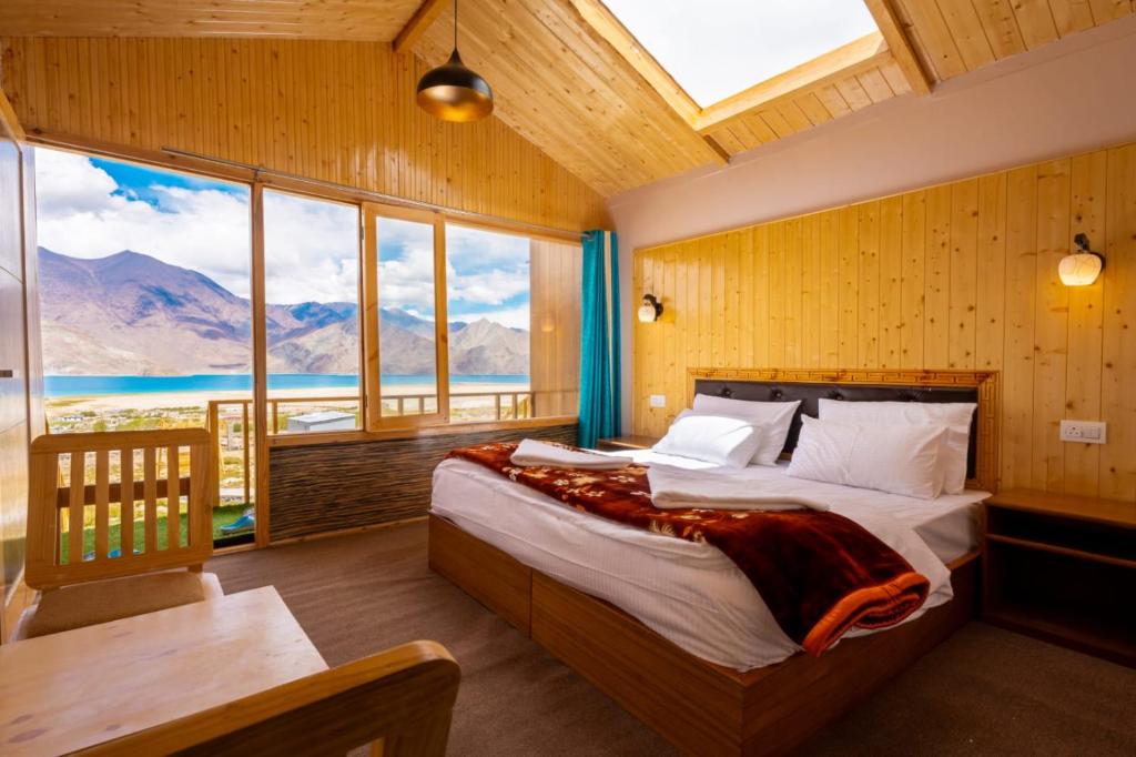 a bedroom with a bed with a view of the mountains at Falcon'S Cottages in Meruk