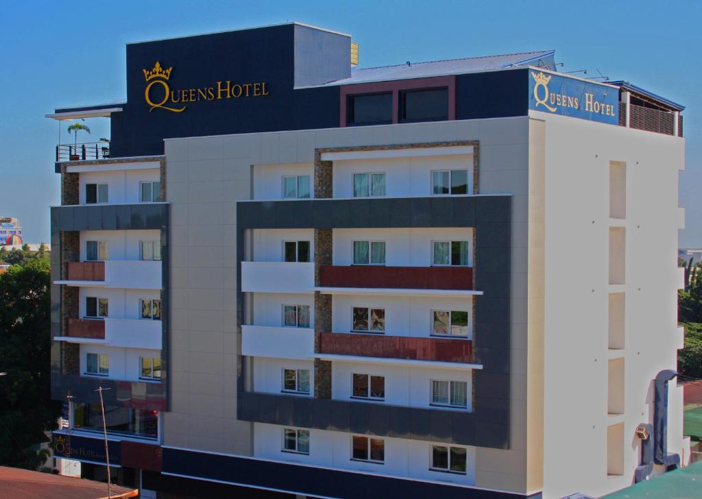 a hotel building with a sign on top of it at Queens Hotel Angeles City in Angeles