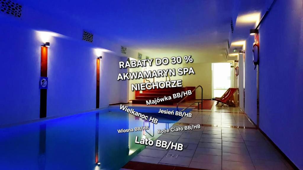 a room with a swimming pool with a sign on the wall at Akwamaryn Spa Niechorze in Niechorze