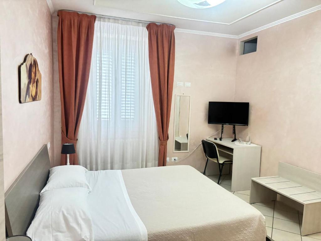 a bedroom with a bed and a desk and a television at Pasubio House appartamento in Campobasso