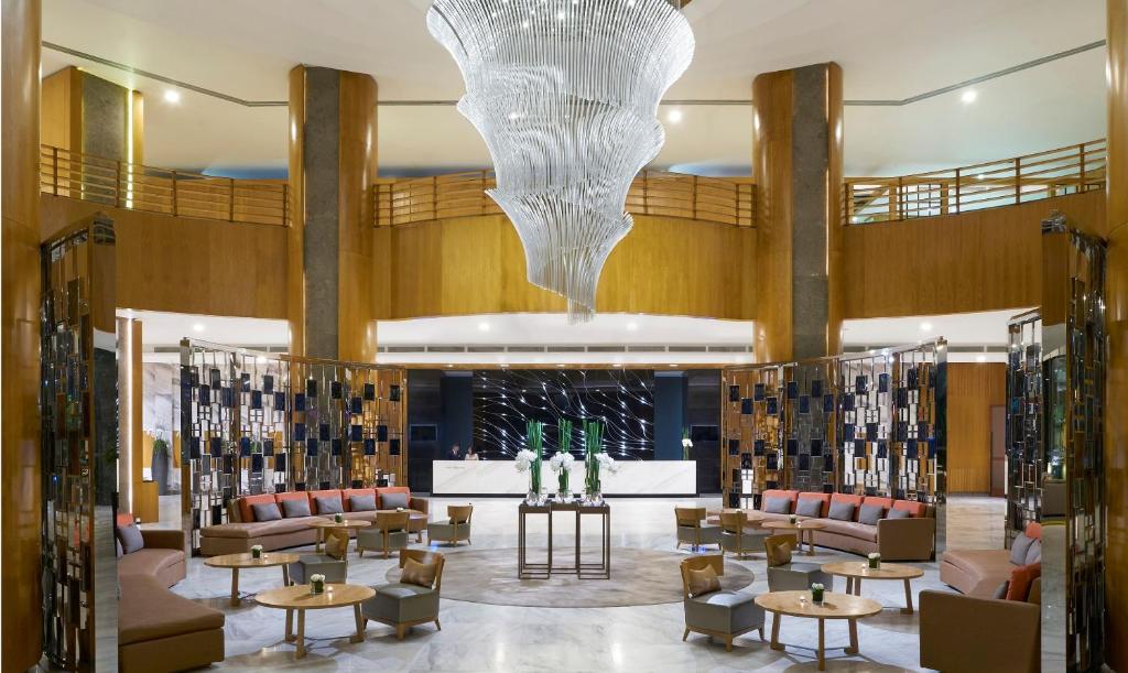 a lobby with couches and tables and a chandelier at Meliá Yangon in Yangon
