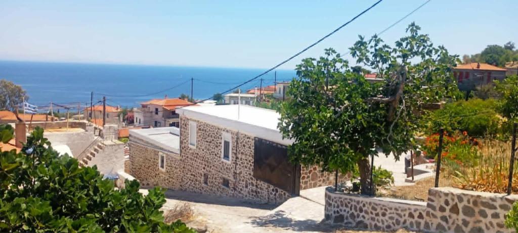 a view of a village with the ocean in the background at Volcanic Stone Cottage Sea View & Yard in Kipséli
