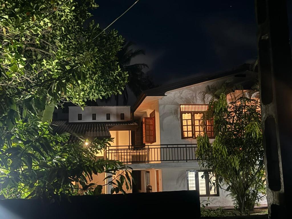 a white house with a balcony at night at Oracle Residence in Anuradhapura