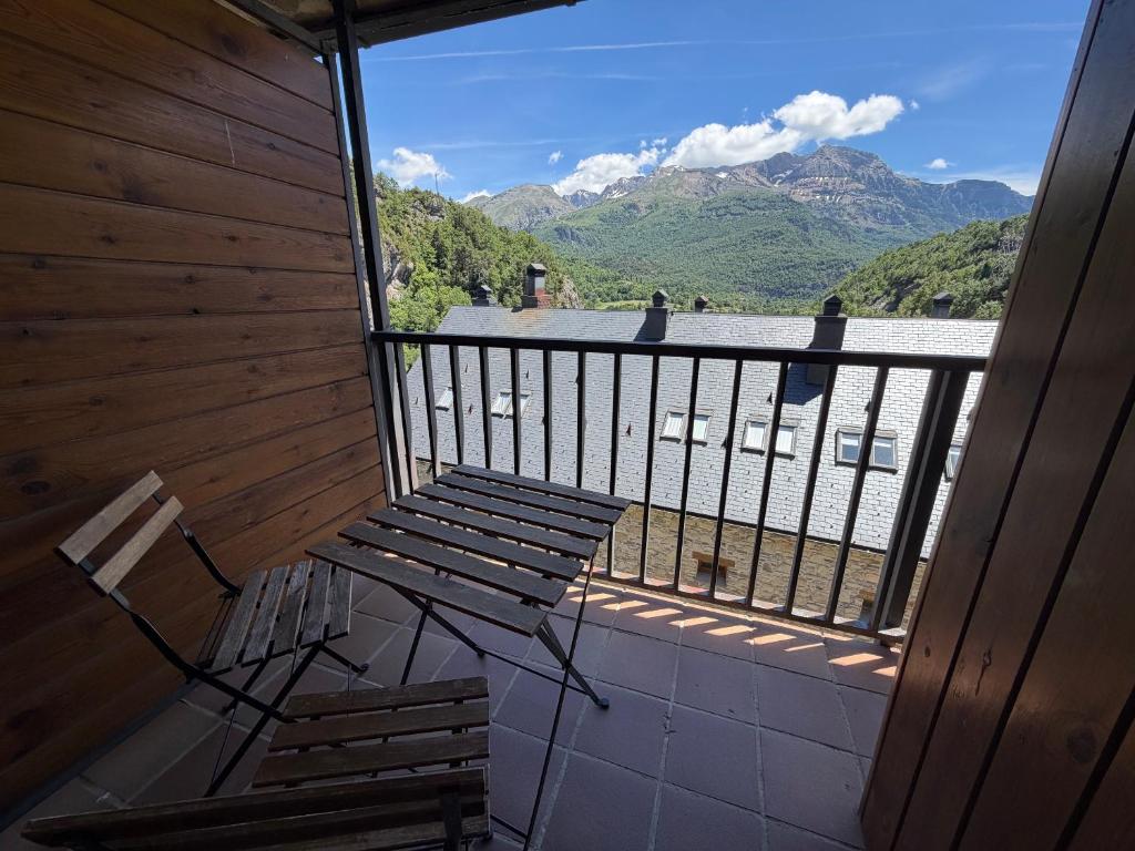ein Balkon mit Bank und Bergblick in der Unterkunft Escuacho in Escarrilla