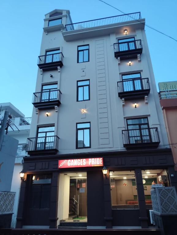a tall white building with windows and balconies at Ganges Pride Hotel in Haridwār