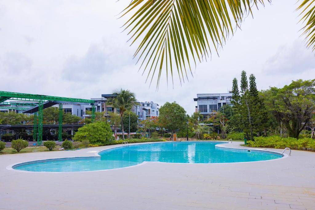 a swimming pool in a park with buildings in the background at TH Luxury Hotel 2 in Phú Quốc