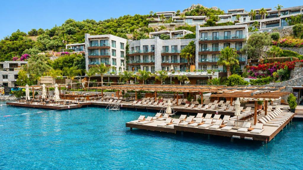 a resort with a marina with chairs and buildings at Mare Deluxe Residences & Villas in Bodrum City