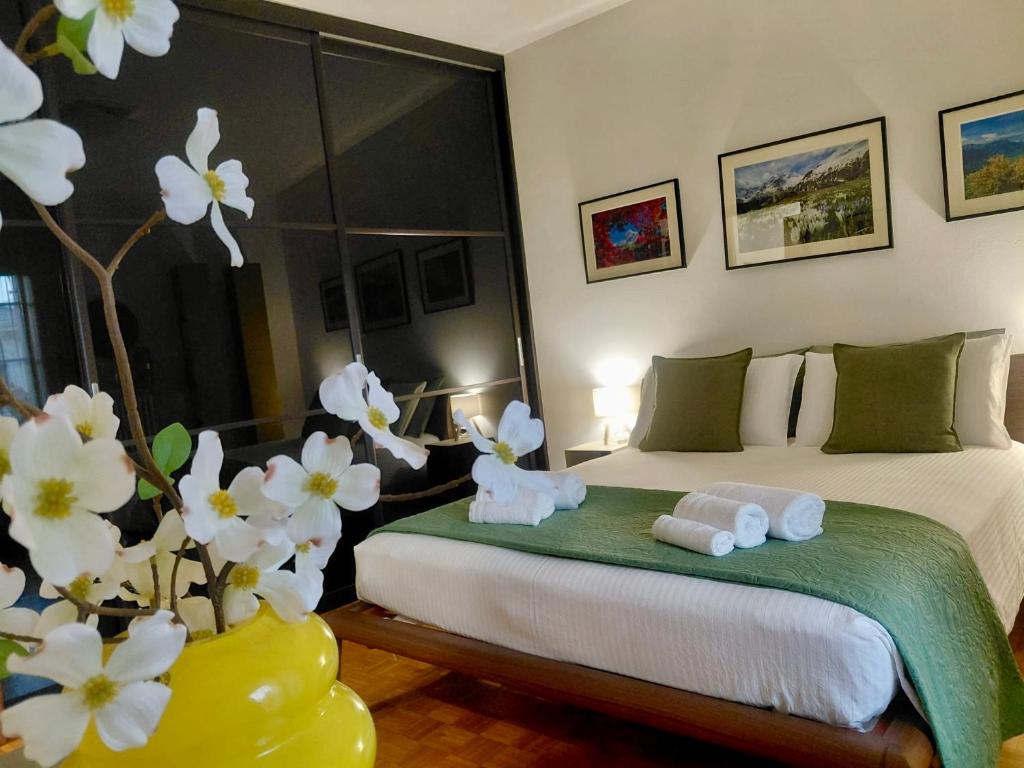 a bedroom with two beds and a vase with flowers at Faggi & Quiet in Mandello del Lario