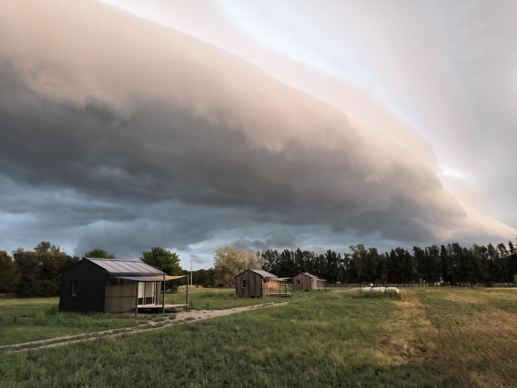 a storm cloud over a farm with houses in a field at Hoxhohl Travel Lodge in Colonia del Sacramento