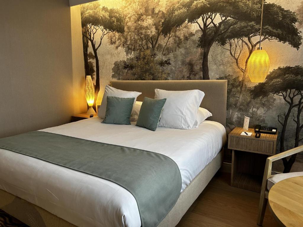a bedroom with a bed with a painting on the wall at Best Western Plus Hotel Admiral in La Tour-de-Salvagny
