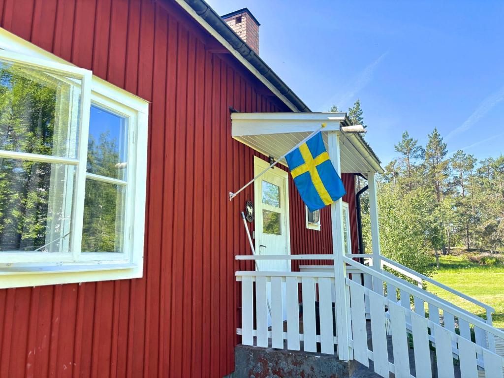 a flag on the front of a red house at Villa Clara in Blankaholm