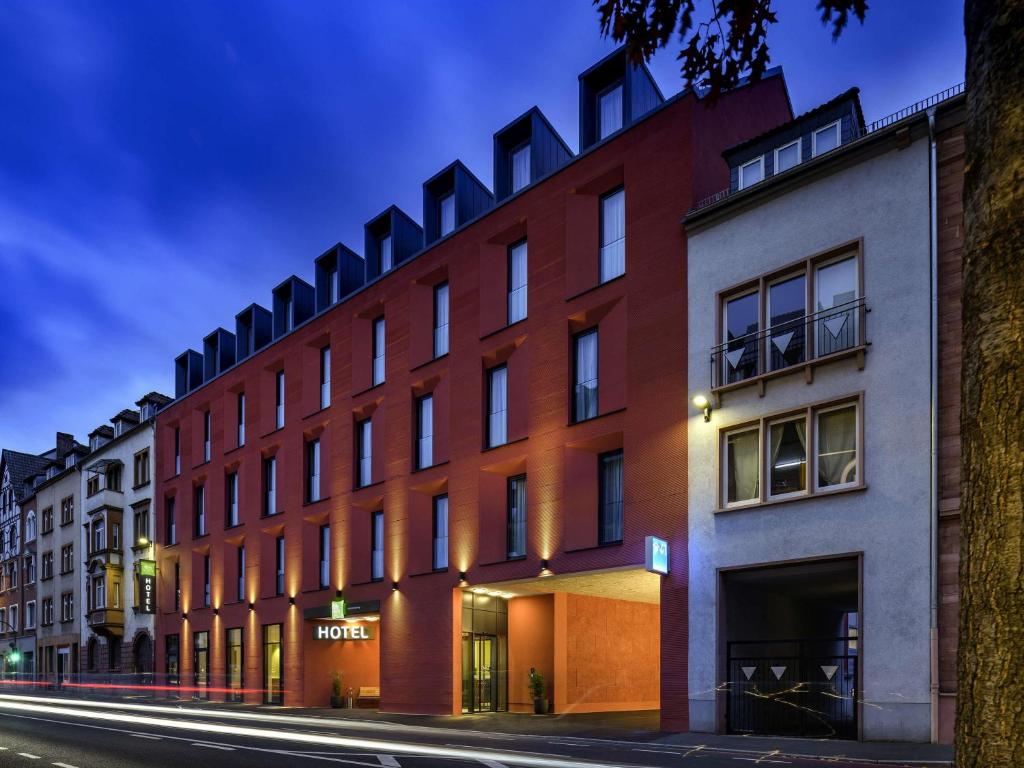 a red brick building on a street at night at Ibis Styles Aschaffenburg in Aschaffenburg