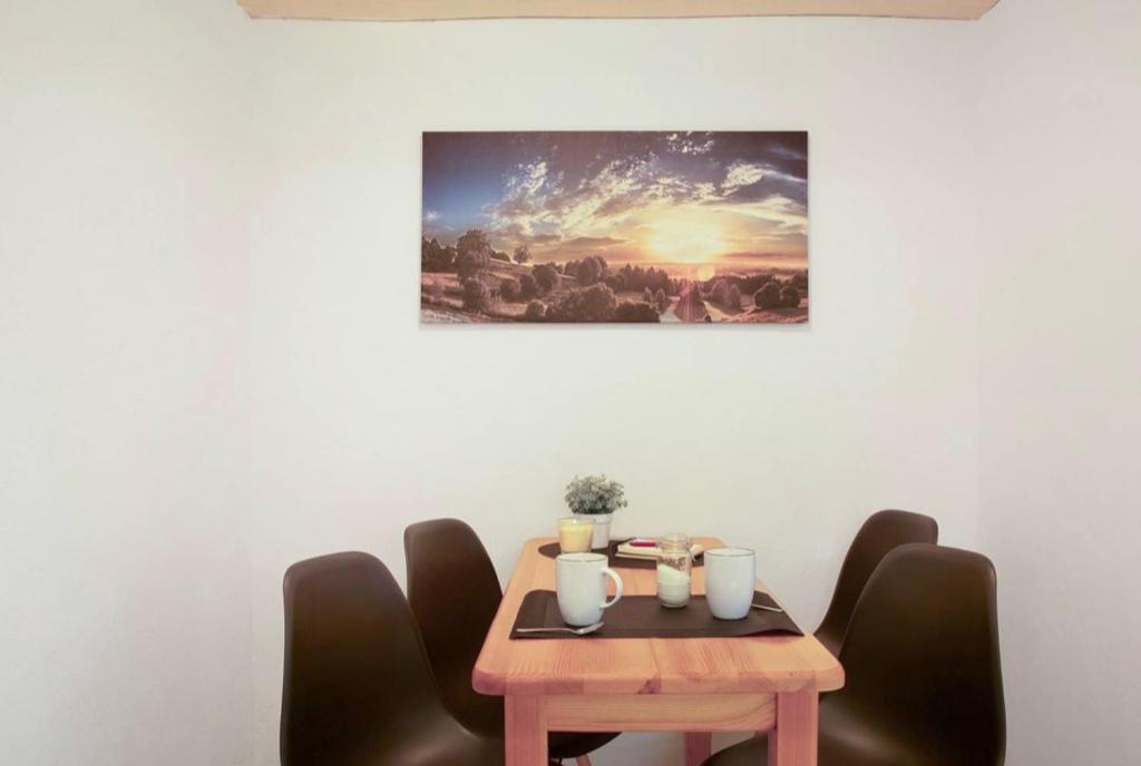a wooden table with chairs around it with a picture on the wall at Seelina in Perach