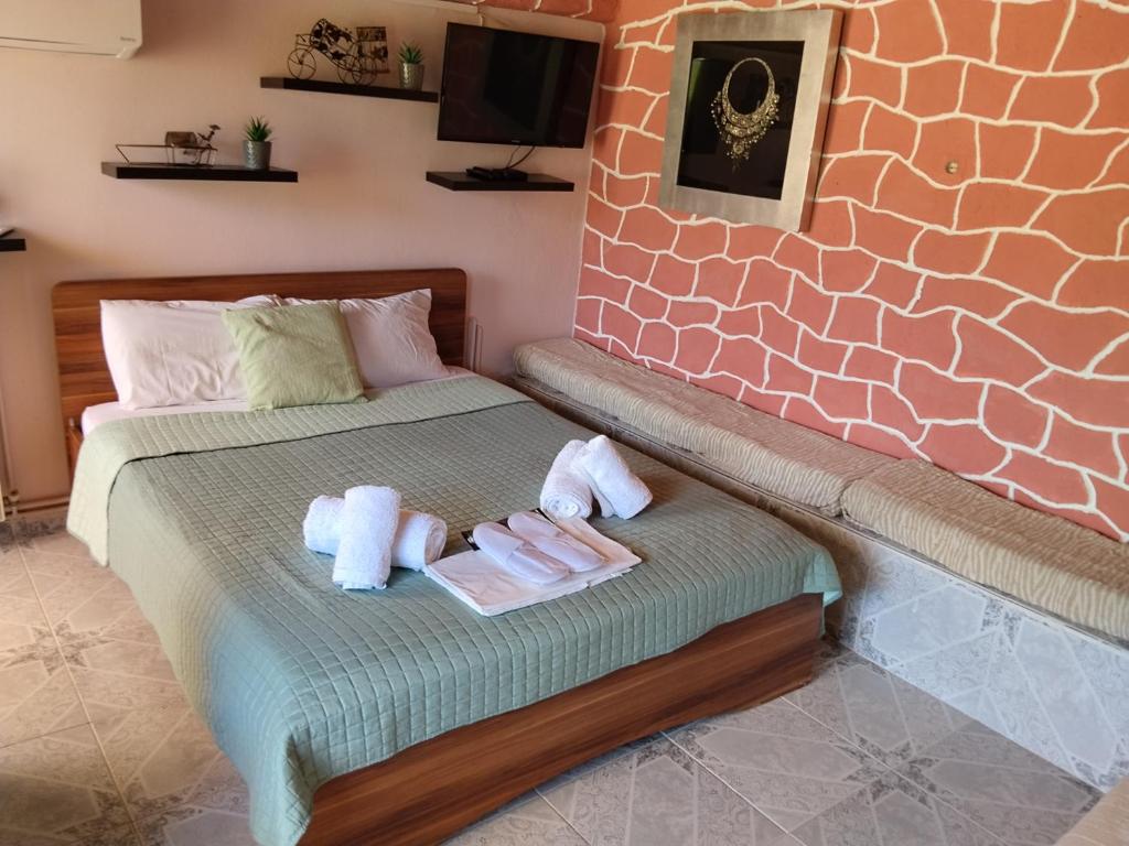 a bedroom with a bed with two towels and a tv at The cave of Cyclops in Makri
