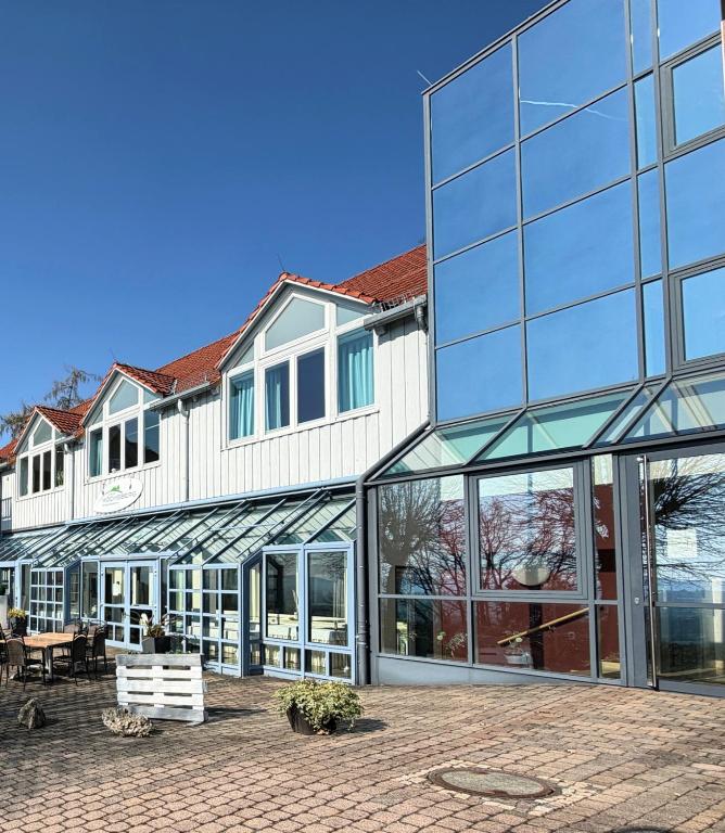 ein großes Gebäude mit Glasfenstern und einer Terrasse in der Unterkunft Inklusions- und Panorama Hotel Kochsberg in Grebendorf
