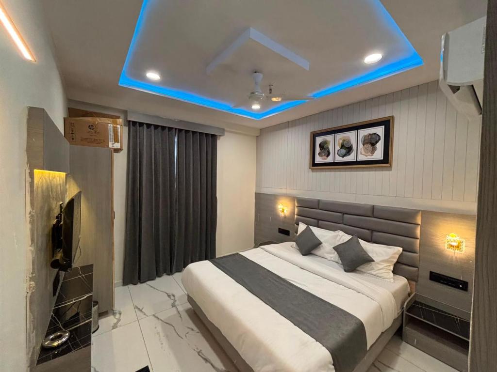 a bedroom with a bed with a blue ceiling at Hotel Planet Lake in Ahmedabad