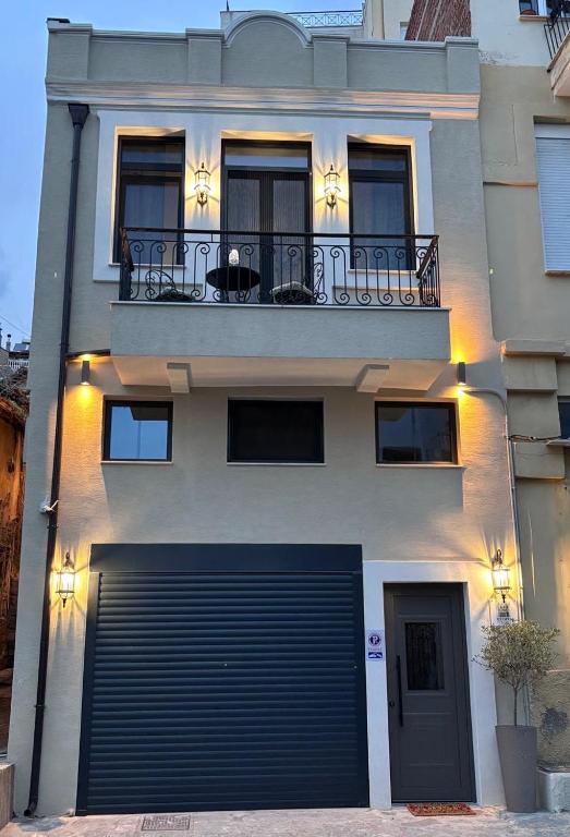 a building with a garage door and a balcony at Utopia House & Garage in Kavála