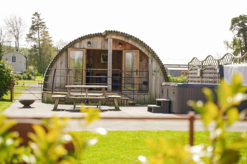 a circular building with a picnic table in a yard at Daisy in Rhayader