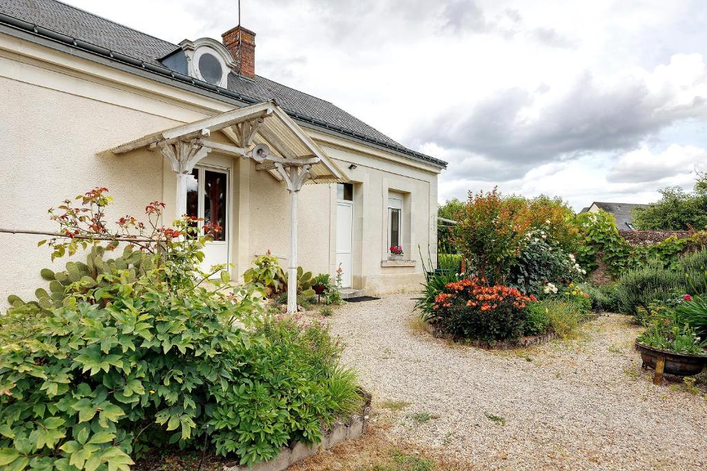 a white house with an awning and some plants at Gîte La Bonnetière in Joué-lès-Tours